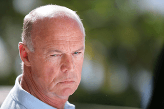 Older man with a serious, concerned expression outdoors in natural light