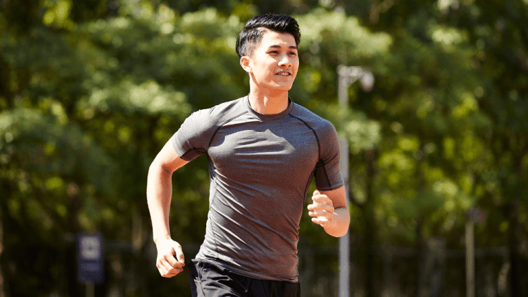 Fit man running outdoors, promoting men's health and active lifestyle